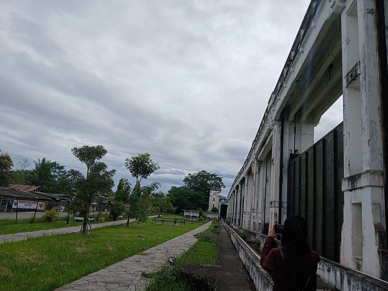 Bangunan gudang memanjang di tepi lahan terbuka