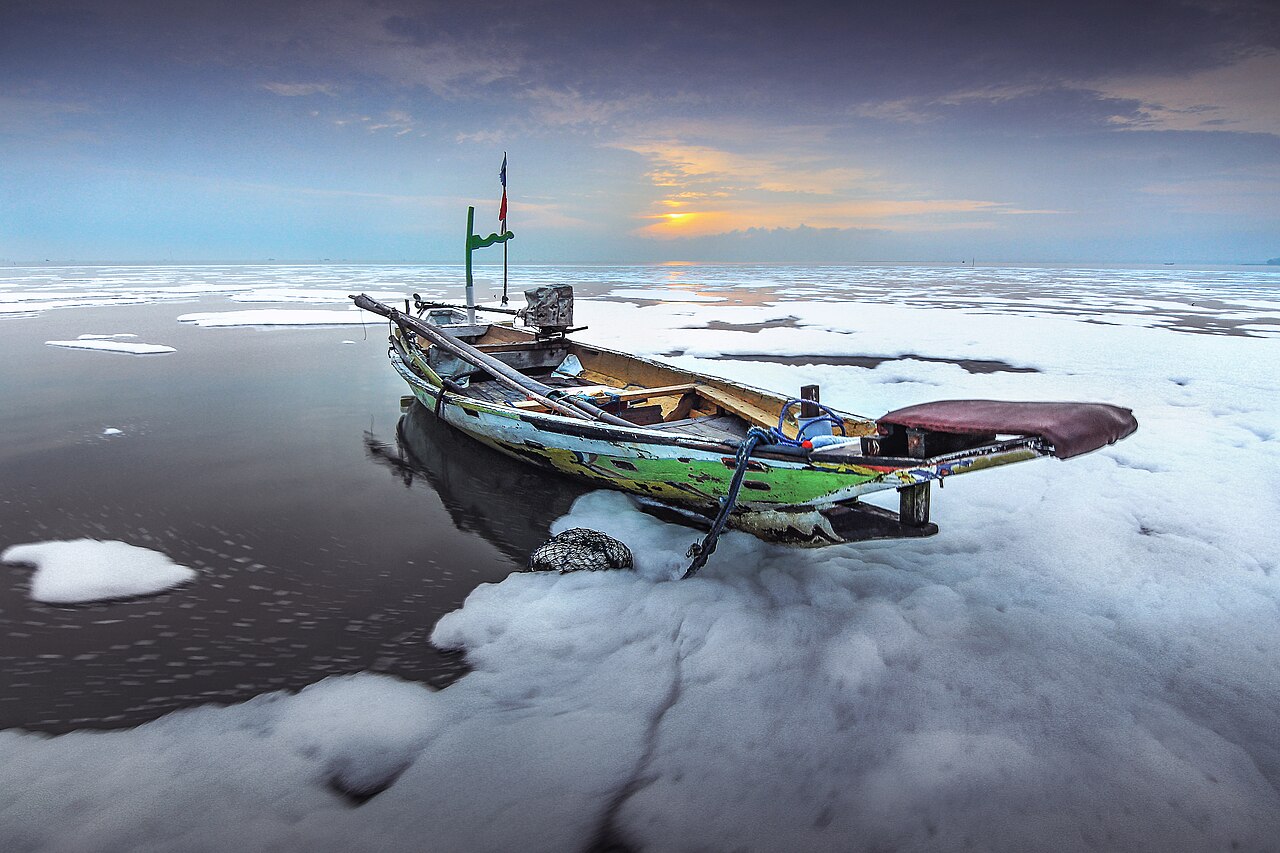 Perahu nelayan di perairan yang tertutup limbah