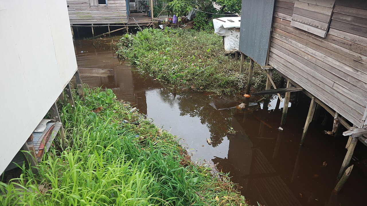 Anak sungai di antara rumah panggung warga