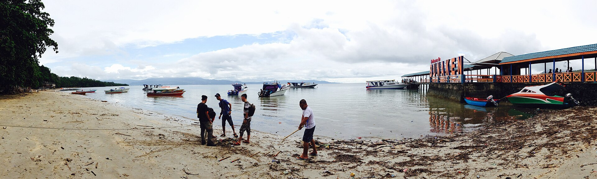 Warga membersihkan sampah di tepi pantai